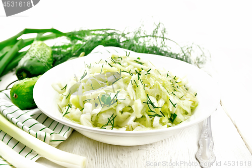 Image of Salad of cabbage with cucumber in plate on light board