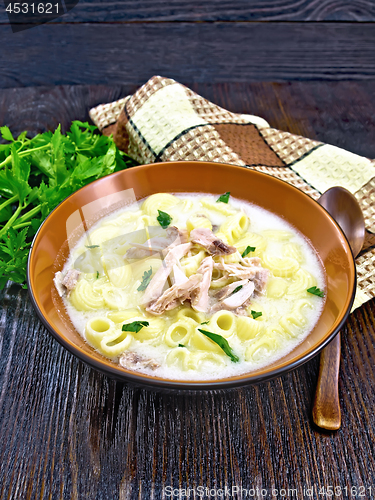 Image of Soup creamy of chicken and pasta in plate on wooden table