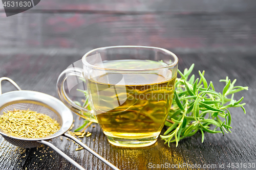 Image of Tea of rosemary in cup with strainer on dark board