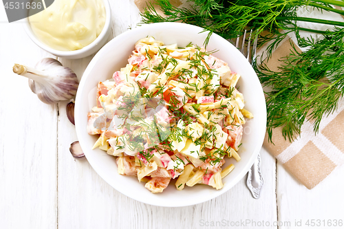 Image of Salad of surimi and eggs with mayonnaise on wooden board top