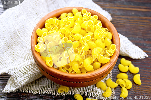 Image of Elbow macaroni in bowl on board