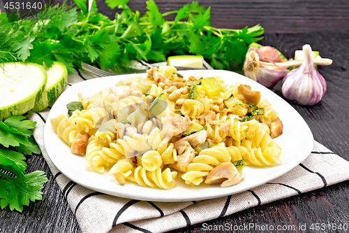 Image of Fusilli with chicken and zucchini in plate on towel