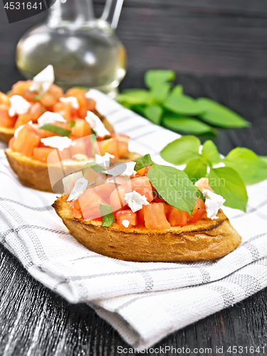 Image of Bruschetta with tomato and feta on wooden board