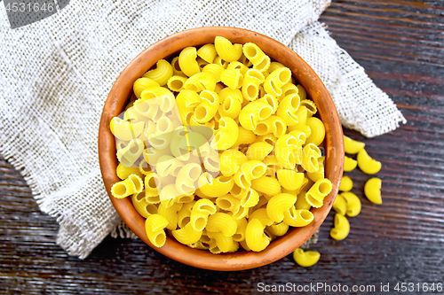 Image of Elbow macaroni in bowl on dark board top