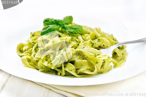 Image of Pasta with pesto sauce in plate on white board