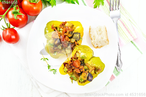 Image of Pepper stuffed with vegetables in plate on light board top