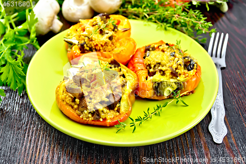 Image of Pepper stuffed with mushrooms and couscous in green plate on tab