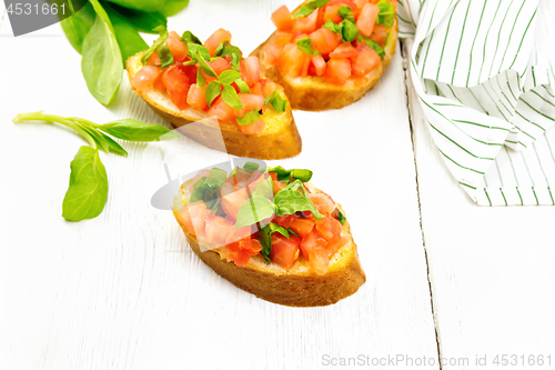 Image of Bruschetta with tomato and spinach on table