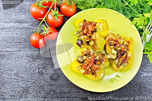 Image of Pepper stuffed with vegetables in green plate on board top