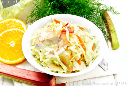 Image of Salad of cabbage and rhubarb in plate on white wooden board