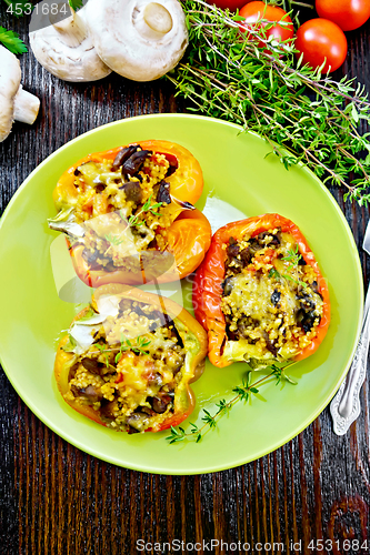 Image of Pepper stuffed with mushrooms in plate on board top