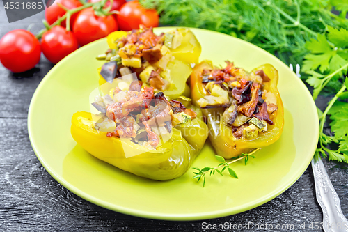 Image of Pepper stuffed with vegetables in green plate on board