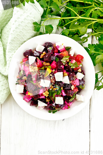 Image of Salad with beetroot and feta in plate on light board top