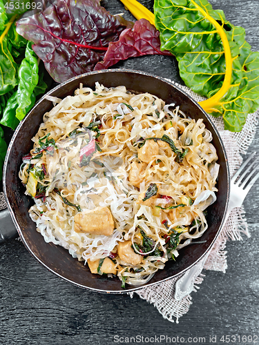 Image of Funchoza with chard and meat in pan on black board top