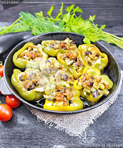 Image of Pepper stuffed with vegetables in pan on dark board