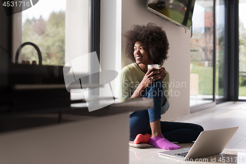 Image of black woman in the living room on the floor