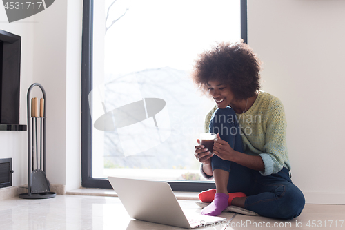 Image of black woman in the living room on the floor