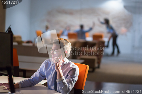 Image of man using mobile phone in dark office