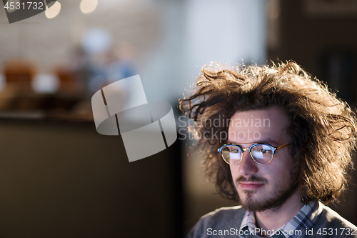 Image of man working on computer in dark office