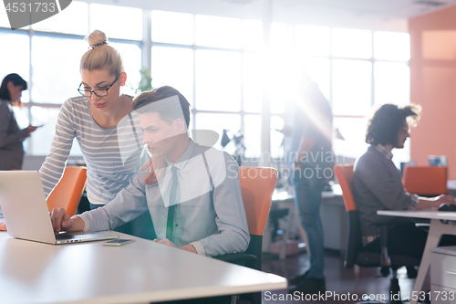 Image of Two Business People Working With laptop in office