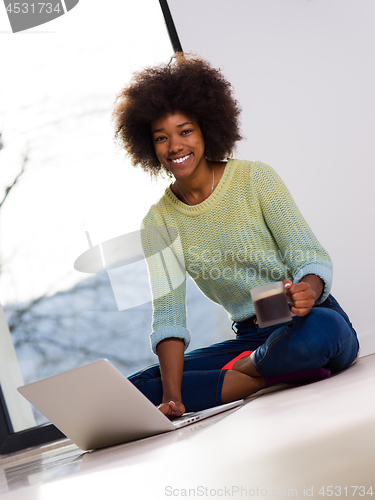 Image of black woman in the living room on the floor