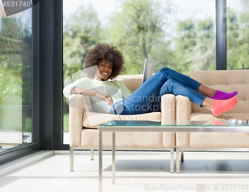 Image of young african american woman at home using digital tablet
