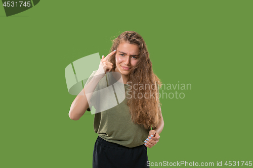 Image of Beautiful female half-length portrait isolated on green studio backgroud. The young emotional surprised woman