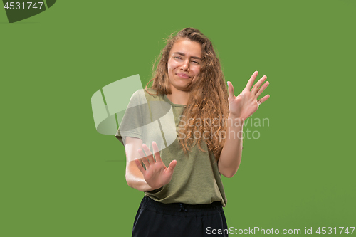 Image of Let me think. Doubtful pensive woman with thoughtful expression making choice against green background