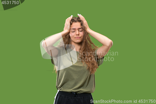 Image of Woman having headache. Isolated over green background.