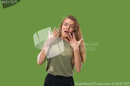 Image of Beautiful woman looking suprised isolated on green