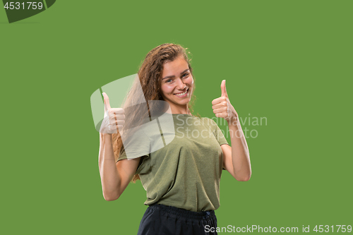 Image of The happy business woman standing and smiling against green background.