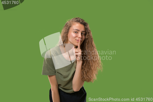 Image of The young woman whispering a secret behind her hand