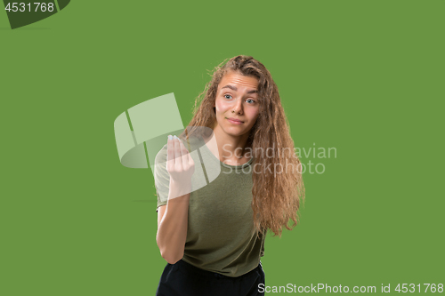 Image of Beautiful female half-length portrait isolated on green studio backgroud. The young emotional surprised woman