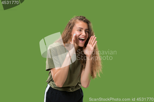 Image of Isolated on green young casual woman shouting at studio