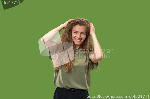 Image of The happy woman standing and smiling against green background.