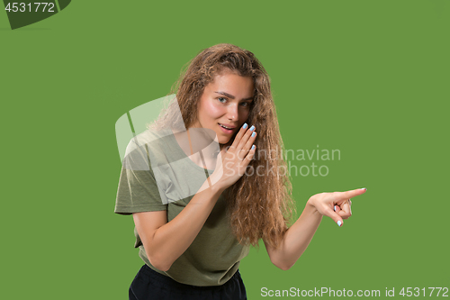 Image of The young woman whispering a secret behind her hand