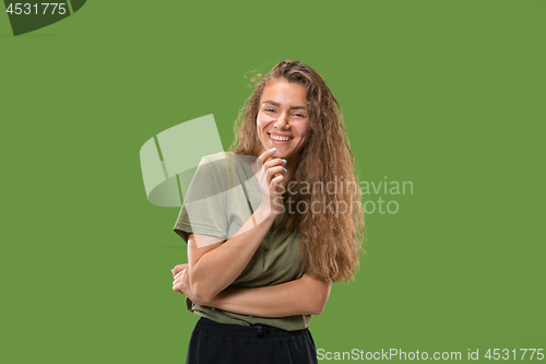 Image of The happy woman standing and smiling against green background.