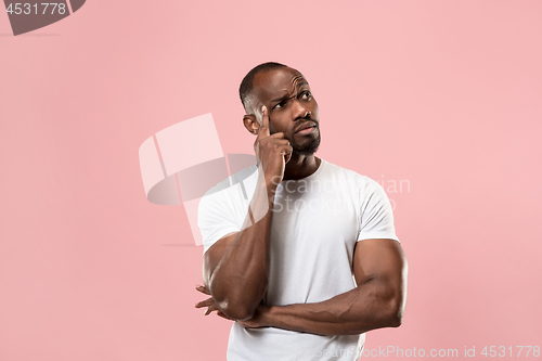 Image of Young serious thoughtful businessman. Doubt concept.