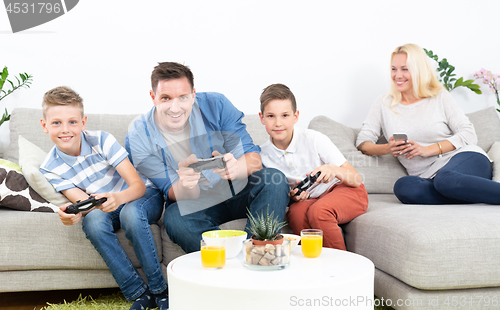 Image of Happy young family playing videogame On TV.