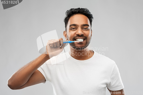 Image of indian man with toothbrush cleaning teeth