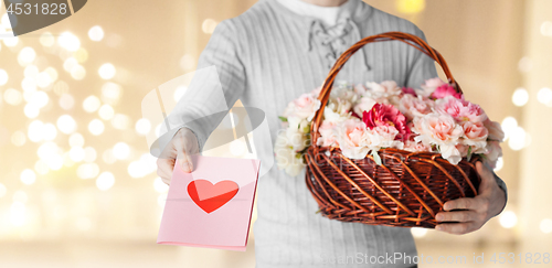 Image of man holding basket of flowers with greeting card