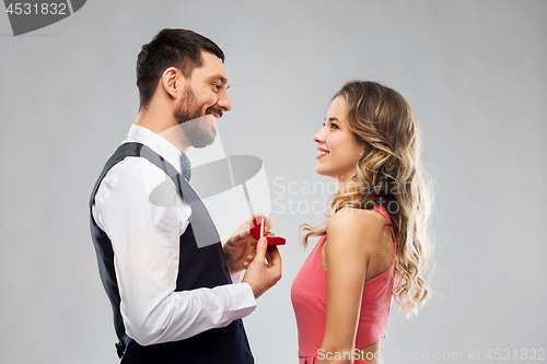 Image of man giving woman engagement ring on valentines day