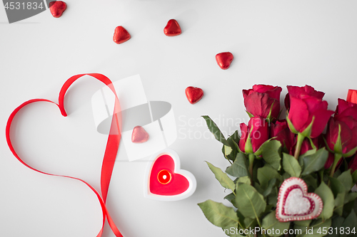 Image of close up of red roses, candies and candle