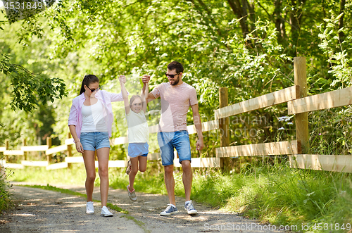 Image of happy family walking in summer park