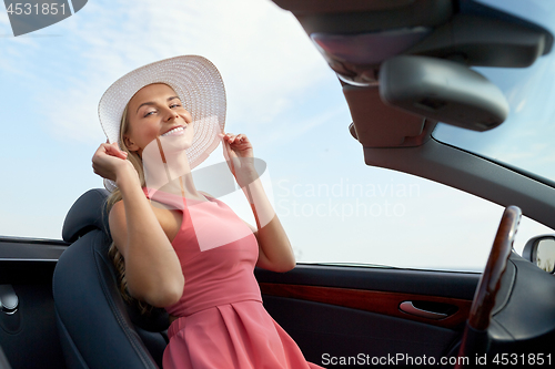 Image of happy young woman in convertible car