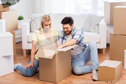 Image of happy couple unpacking boxes at new home