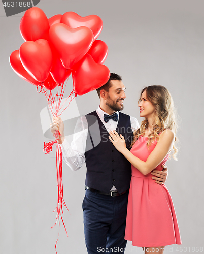 Image of happy couple with red heart shaped balloons