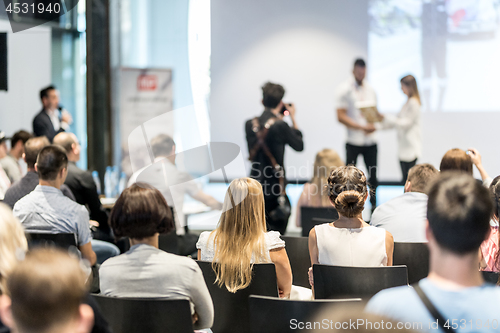 Image of Young business team receiving award at best business project competition event.