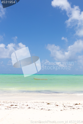 Image of Fishing boat on picture perfect white sandy beach with turquoise blue sea, Paje, Zanzibar, Tanzania.