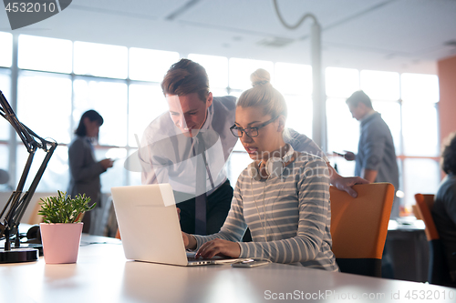 Image of Two Business People Working With laptop in office